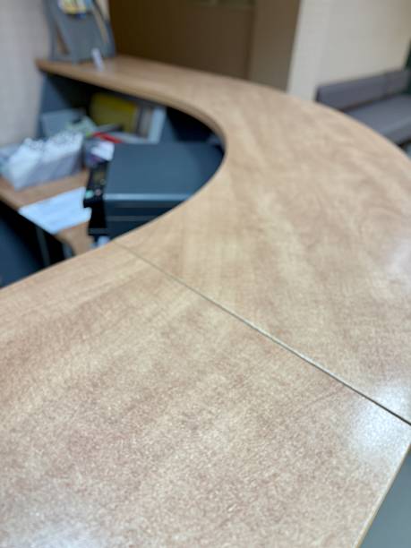 Professional Medical Reception With Tidy Workspace And Welcoming Ambiance, Efficiently Organized Clinic Reception Featuring Curved Wooden Desk And Soft Ambient Illumination