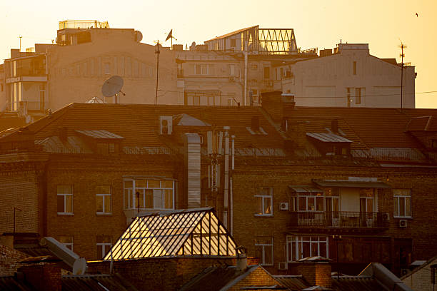 Kyiv, Ukraine. Bright golden morning sunlight illuminating the rooftops and attic windows of historical residential buildings in the city center. Urban architectural landscape near Pechersk.