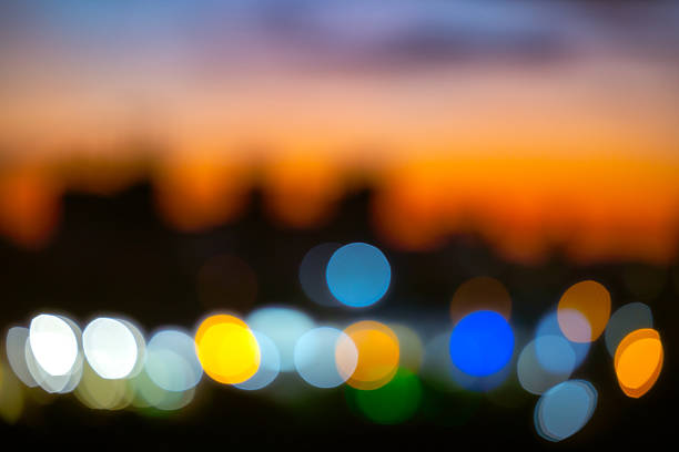 Abstract night city circles bokeh light background. Soft defocused urban lights with warm orange and cool blue glow for peaceful evening atmosphere and professional commercial photography use.