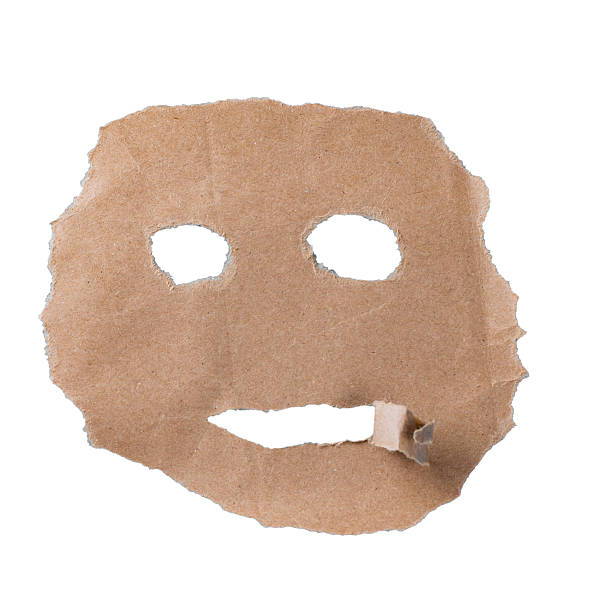 Torn kraft paper with cut eye and mouth holes isolated on white, expressive abstract face concept.