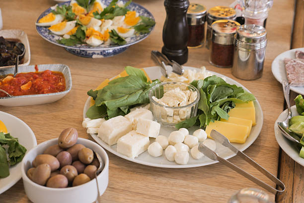 Delicious spread of cheese and fresh greens on wooden table