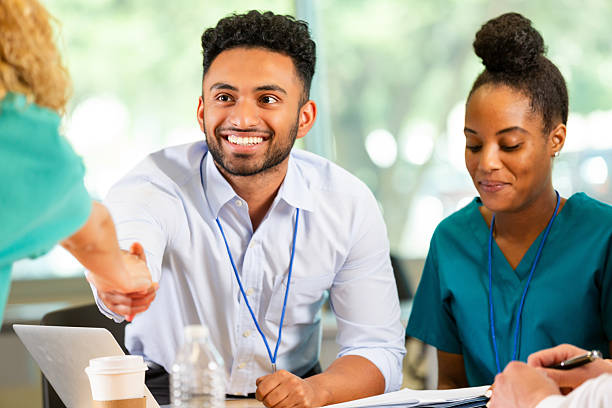 istock Colleagues greet each other warmly indoors, discussing important matters and collaborating for success. 2254383605