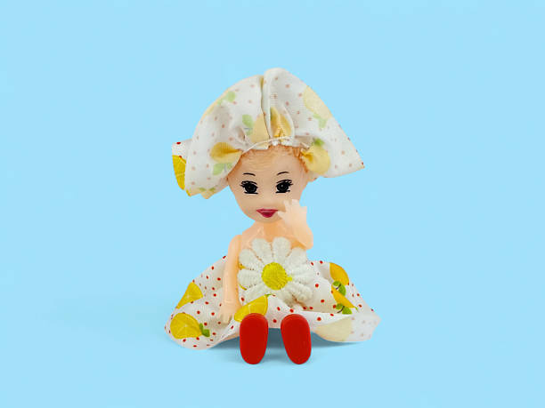 istock Cute Little Toy Doll Sitting On Blue Background 2254384190