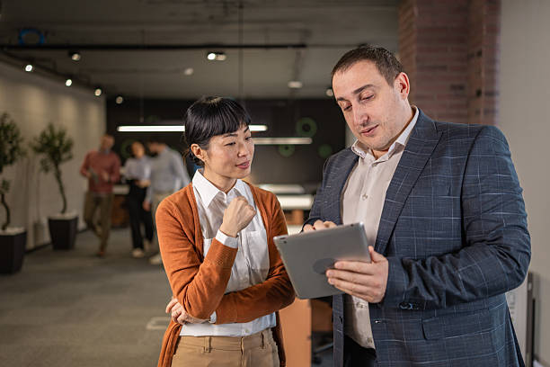 istock Diverse business colleagues discussing project on tablet in modern office 2254385440