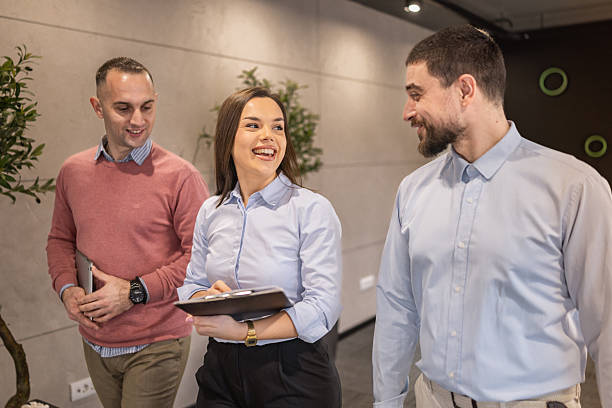 istock Diverse professional team walking and laughing  in modern office 2254385611