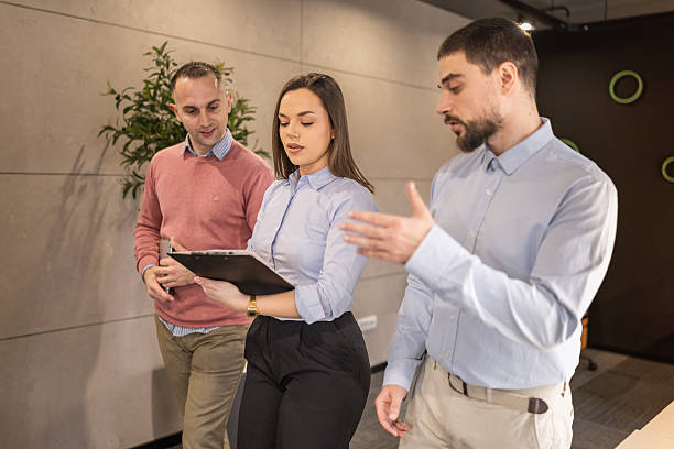 istock Business team of tree professionals reviewing documents on clipboard 2254386171