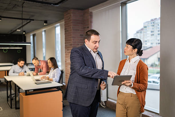 istock Diverse business colleagues discussing project on tablet in modern office 2254386348