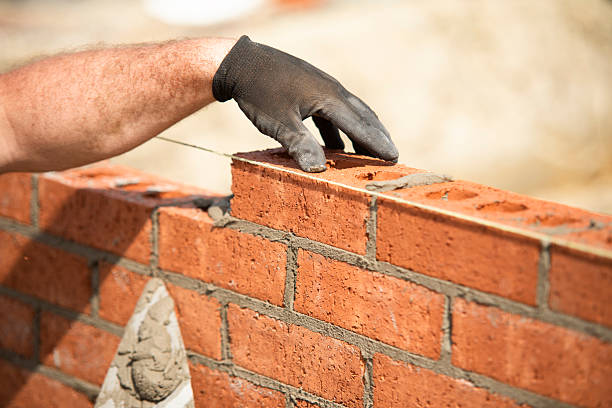 istock Close-up of Bricklayer laying red bricks on building site 2254386612