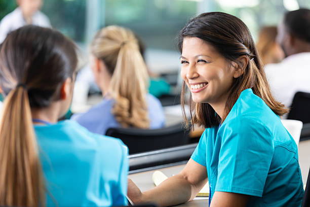 istock Nurses in blue scrubs smiling and talking during a healthcare training session. 2254387052
