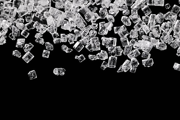 istock Macro shot of falling sugar crystals isolated on black background. 2254389240