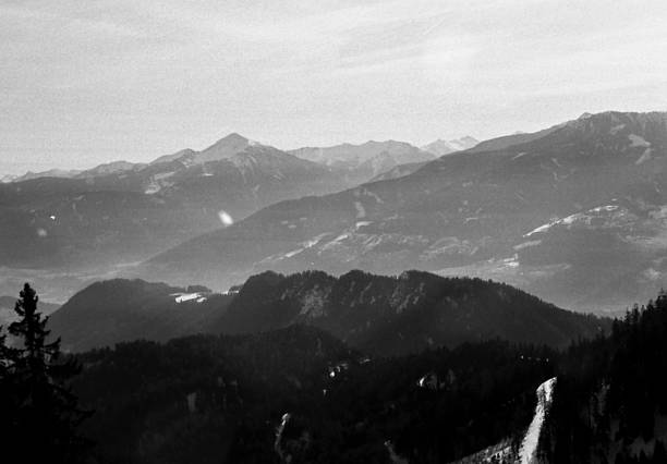 Black and white scanned film image of misty mountain valley with soft focus and light leak adding dreamy vintage quality