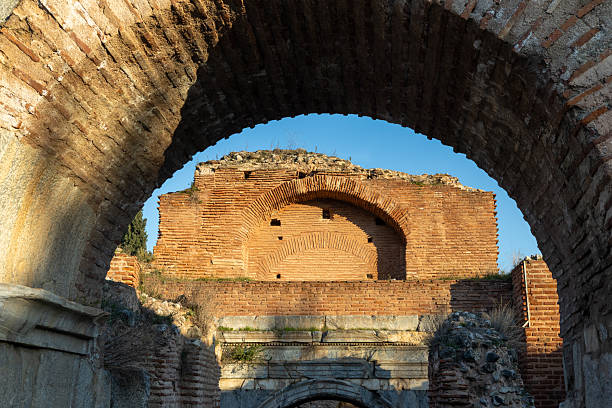 Ancient romanesque arch structure framing other historic brickwork and ruins under a clear blue sky, highlighting a rich history and cultural heritage. Iznik, bursa, turkey
