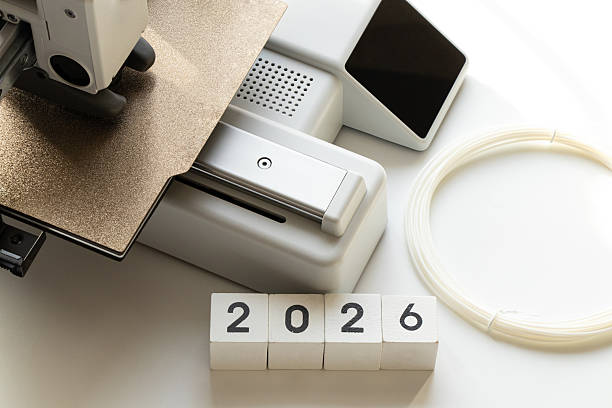 istock Desktop 3D printer with spool of plastic filament on white background and year 2026 on cubes. Modern additive manufacturing technologies 2254394846