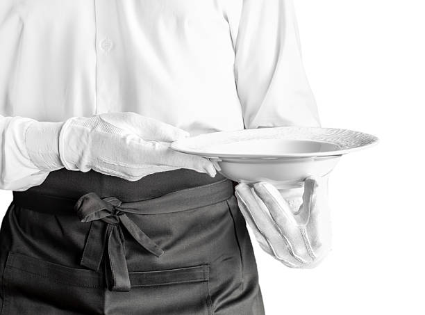 Portrait of cheerful waiter holding a tray with orange juices looking at camera smiling very happy