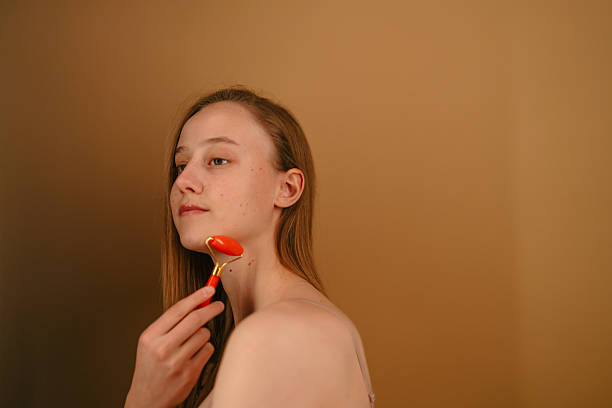 istock Beautiful young woman using a jade roller as part of her skincare routine 2254397750