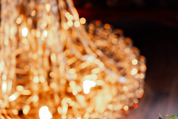 A large chandelier shines brightly above as people socialize and enjoy the evening event. The warm glow of the lights adds to the lively atmosphere of the gathering.