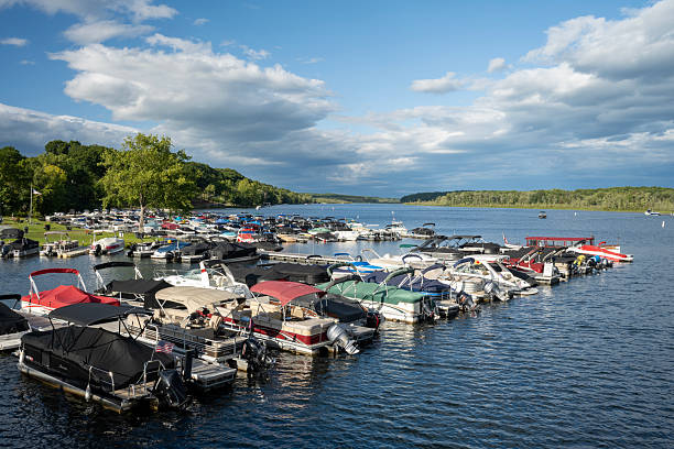 Duluth, Minnesota, USA - August 11, 2024: Family standing on a dock at Look Lake board a pontoon boat to take a cruise around the lake at sunset
