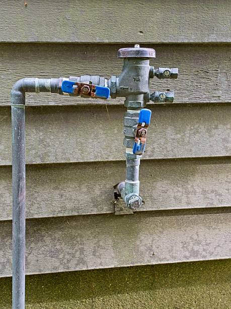 istock Plumbing pipe, valves protruding through exterior wall 2254403045