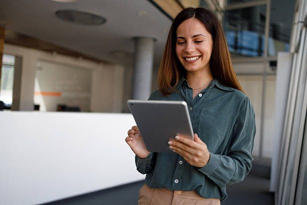 istock Professional woman smiling using digital tablet in modern office, managing business communication and workflow 2254403894