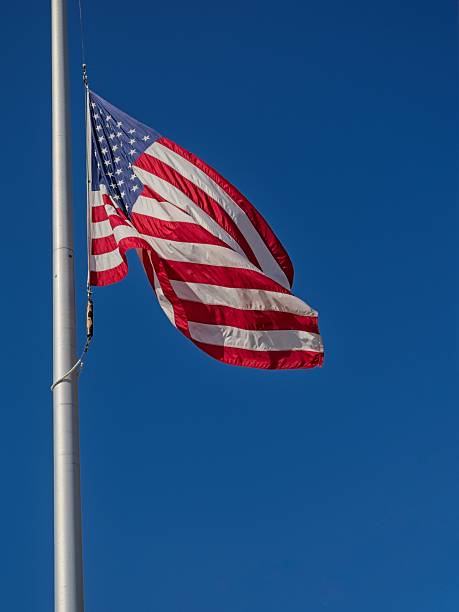 istock American flag waving in blue sky 2254404325