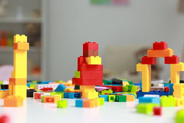 Construction toy. Figures made with building bricks and colorful blocks on white table indoors, closeup