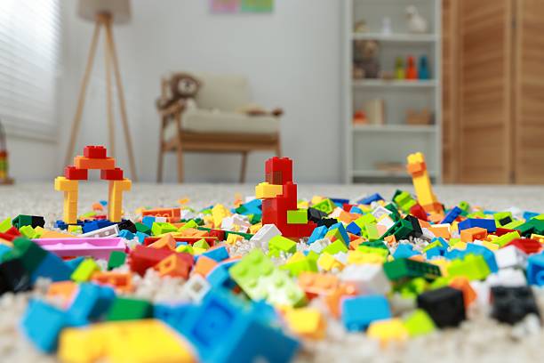 Construction toy. Figures made with building bricks and colorful blocks on floor indoors, closeup