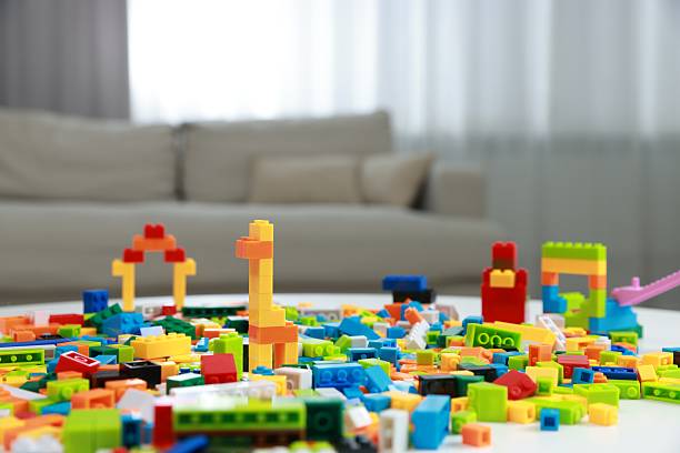 Construction toy. Figures made with building bricks and colorful blocks on table indoors, closeup