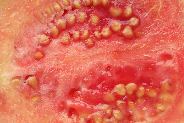 Juicy guava fruit with seeds as background, top view
