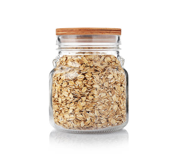 Glass jar with oat flakes isolated on white