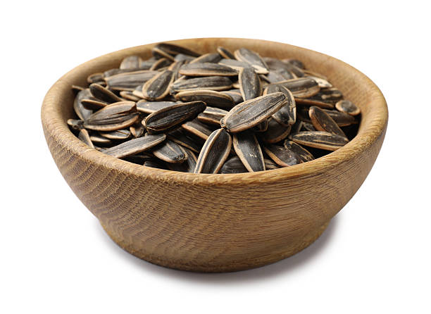 istock Sunflower seeds in bowl isolated on white 2254407244