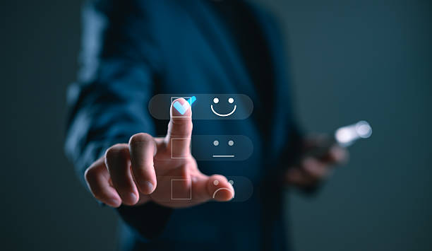 istock Customer satisfaction and digital feedback concept. Businessman selecting happy face icon on virtual screen for rating service experience using futuristic interface. 2254409554