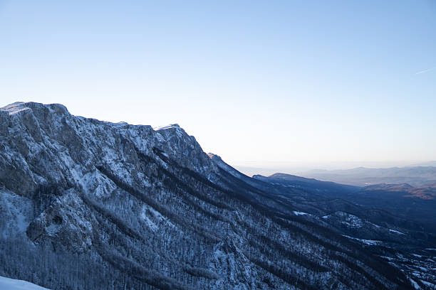 istock Mountain ridge covered with snow with mountain range in the back. Winter time. 2254409854