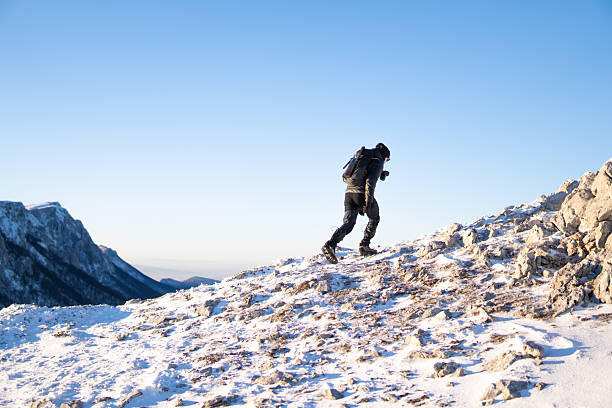 istock Man walking up the mountain peak with mountain range in the back 2254409864
