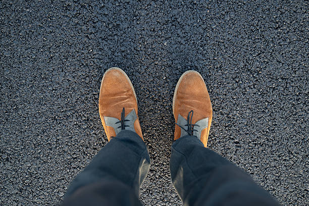 istock Man's shoes on fresh asphalt surface 2254410814