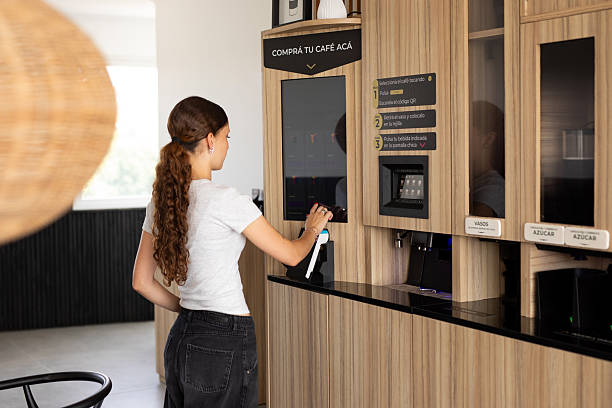 istock Young woman paying at a smart coffee vending machine 2254411509