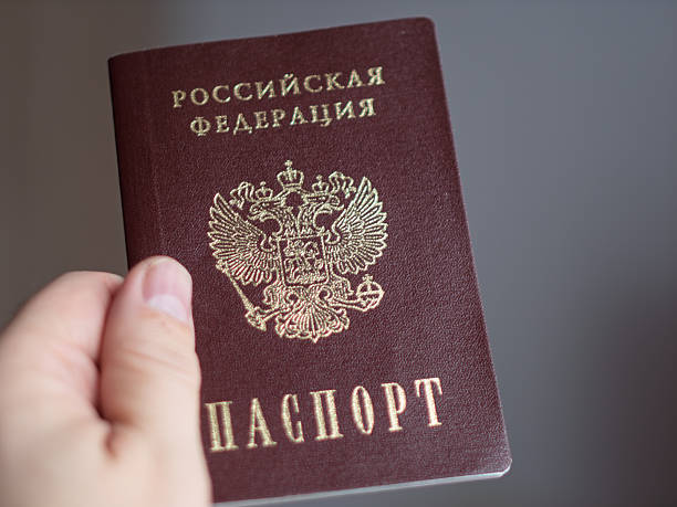 istock Russian Passport Held in a Hand with Official Emblem 2254413192