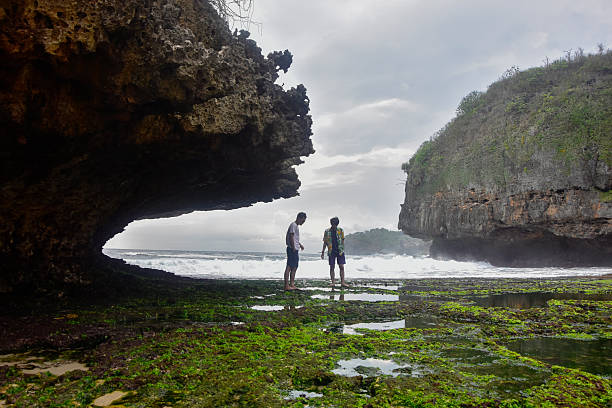asian elderly male travel and hike alone - he healthily enjoy the cavern sightseeing in Kenting Taiwan