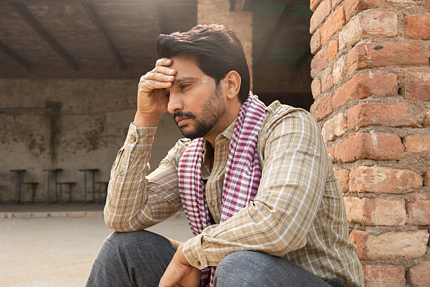 Young indian thoughtful sad man feeling alone. sadness, depression. Rural india. Unemployment