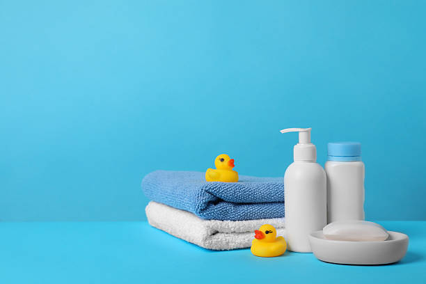 istock Baby cosmetic products, bath ducks and towels on light blue background. Space for text 2254434220