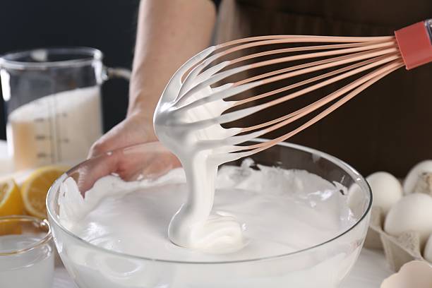 istock Woman making whipped cream with whisk at table, closeup 2254435232
