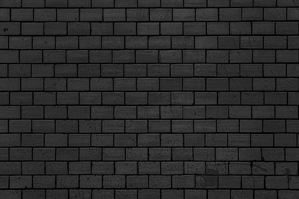 istock Wall of vintage black bricks covered with cracked glaze. 2254436815