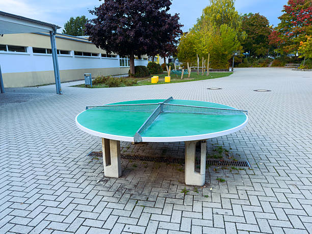 istock Ping pong table in a serene outdoor park setting surrounded by vibrant trees and modern architecture during a calm evening 2254438270