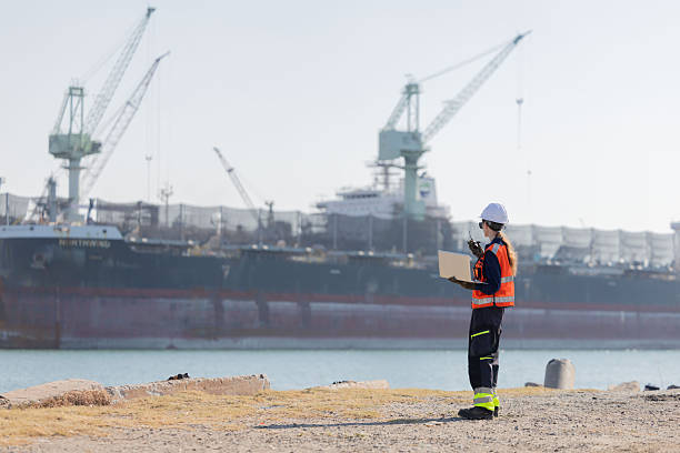 istock Worker work at a port with a cargo ship in the background 2254438895