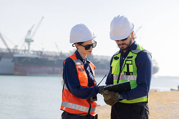 istock Workers discuss plans at a port with a cargo ship in the background 2254438900