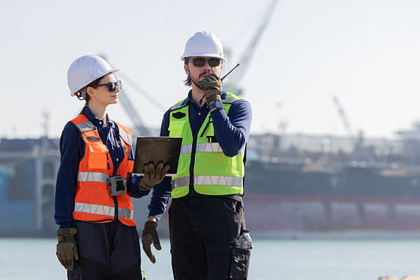istock Workers discuss plans at a port with a cargo ship in the background 2254438903