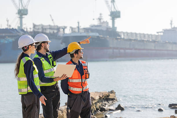 istock Workers discuss plans at a port with a cargo ship in the background 2254438917
