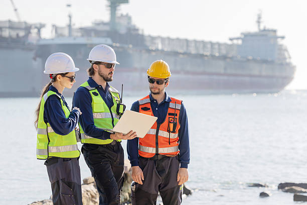 istock Workers discuss plans at a port with a cargo ship in the background 2254438936