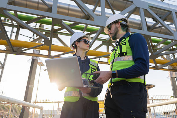 istock Petroleum engineers with hardhat working at oil refinery site 2254438957