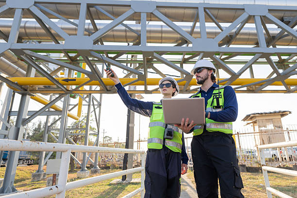 istock Petroleum engineers with hardhat working at oil refinery site 2254438962