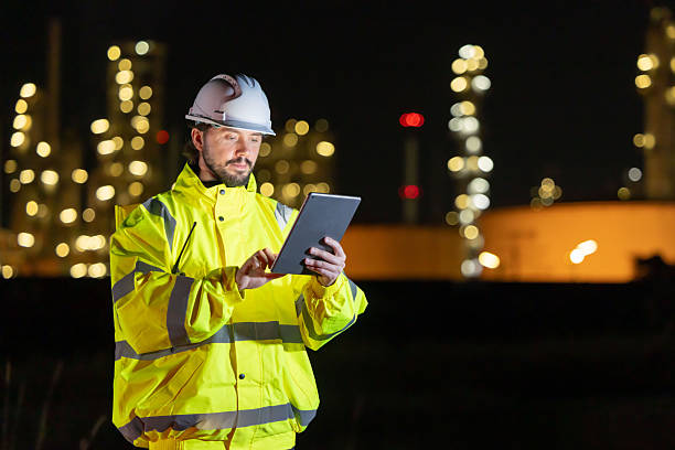 istock Petroleum engineers working at oil refinery site at night 2254439058